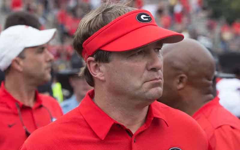 Kirby Smart wearing a visor, mean mugging toward the football field